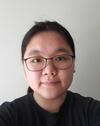 Image of young Asian scholar wearing black rimmed glasses and a black long-sleeved t-shirt and hair in a pony tail.